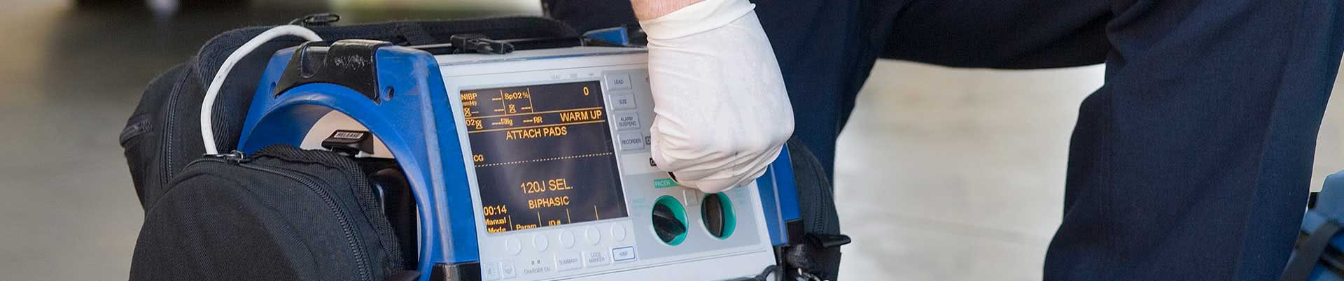 Notfallmedizinische Ausstattung - Arzt stellt tragbaren Defibrillator ein